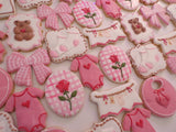 23sweets.com Collection of decorative pink and white cookies shaped like baby-themed items on a white background
