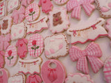 23sweets.com Collection of decorative pink and white cookies shaped like baby-themed items on a white background