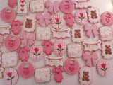 23sweets.com Collection of decorative pink and white cookies shaped like baby-themed items on a white background