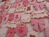 23sweets.com Collection of decorative pink and white cookies shaped like baby-themed items on a white background