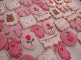 23sweets.com Collection of decorative pink and white cookies shaped like baby-themed items on a white background