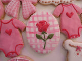 23sweets.com Collection of decorative pink and white cookies shaped like baby-themed items on a white background
