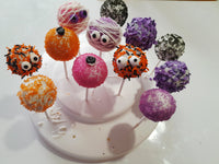Colorful Halloween cake pops with decorative toppings on a white plate, by 23sweets.com