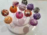 Colorful Halloween cake pops with decorative toppings on a white plate, by 23sweets.com