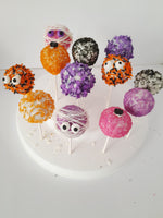Colorful Halloween cake pops with decorative toppings on a white plate, by 23sweets.com