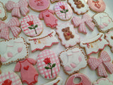 23sweets.com Collection of decorative pink and white cookies shaped like baby-themed items on a white background